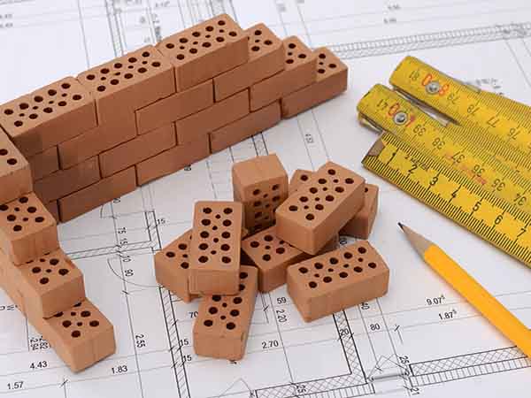 Custom Home Builder - drawing plans for custom home with plans ruler and bricks